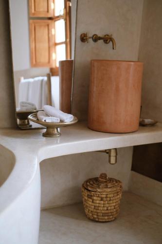 un piano del bagno con lavandino e specchio di Riad L'Atelier a Marrakech