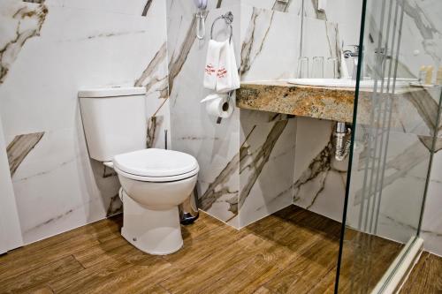a white bathroom with a toilet and a sink at Plovdiv City Center Hotel in Plovdiv