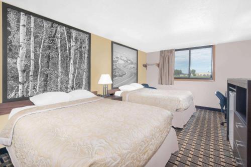 A bed or beds in a room at Super 8 by Wyndham Watertown
