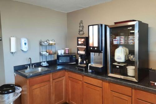 a kitchen with a sink and a refrigerator at Super 8 by Wyndham Watertown in Watertown
