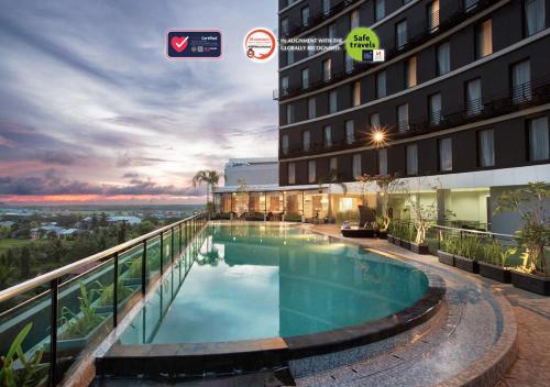 un hotel con piscina en el balcón de un edificio en Swiss-Belinn Singkawang, en Singkawang