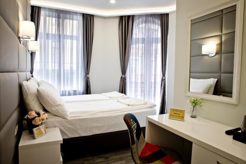 Habitación de hotel con cama y espejo en Plovdiv City Center Hotel en Plovdiv