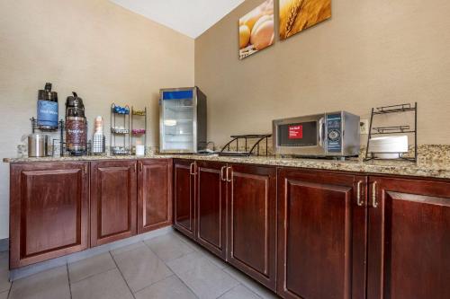 a kitchen with wooden cabinets and a counter with a microwave at Comfort Inn Meadowlands in Washington