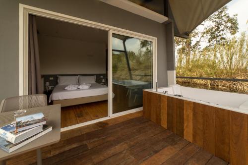 a bedroom with a tub and a bedroom with a bed at Nabi Resort Glamping & SPA in Castel Volturno