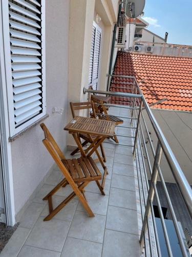 two chairs and a table on a balcony at Skunca’s house in Novalja