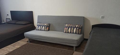 TuymazyにあるApartment on Ostrovskogo 28のソファ、ベッド、ベッド、椅子が備わる客室です。