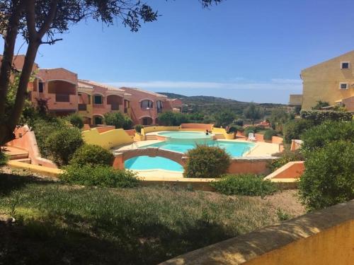 un complexe avec 2 piscines dans une cour dans l'établissement Residenze Zodiaco, à Santa Teresa Gallura