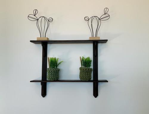 a black shelf with three plants on it at Casa da Zéfinha, em Cinfães, no Douro in Cinfães