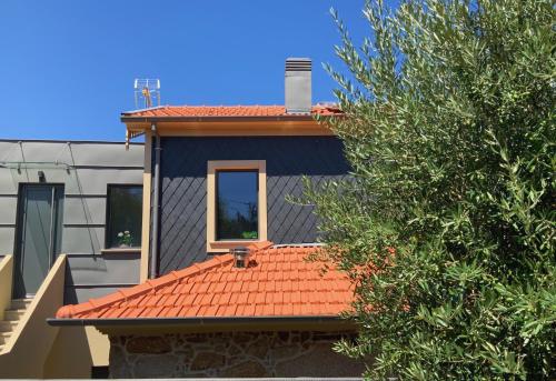 a house with a red roof and a window at Casa da Zéfinha, em Cinfães, no Douro in Cinfães