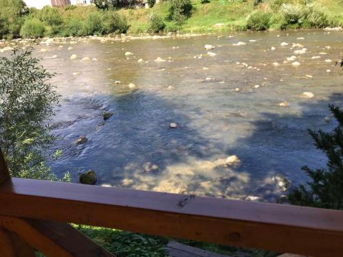 a view of a river from a wooden fence at Yablunevyi Tsvit in Yaremche
