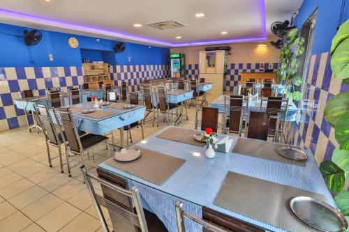 a restaurant with tables and chairs in a room at Hotel TamilNadu - Madurai I in Madurai