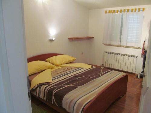 a bedroom with a bed with yellow pillows at kutlesa 2 in Opatija