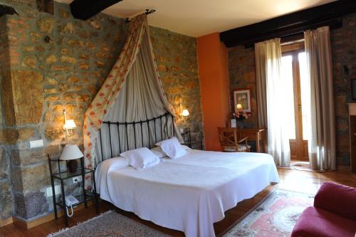 um quarto com uma cama de dossel branca em Palacio Garcia Quijano em Los Corrales de Buelna