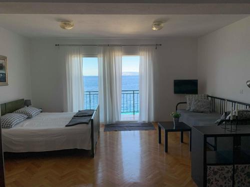 a bedroom with a bed and a view of the ocean at BEACH SEA VIEW APPARTMENT in Podgora