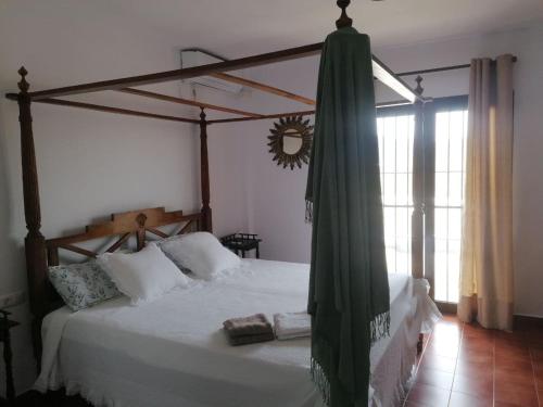 1 dormitorio con 1 cama grande con dosel en Cortijo El Aire, Parque Natural Cabo de Gata, en El Pozo de los Frailes