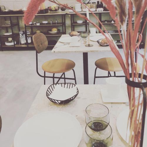 a table with two chairs and a vase on it at Hôtel L'Adresse in Tours
