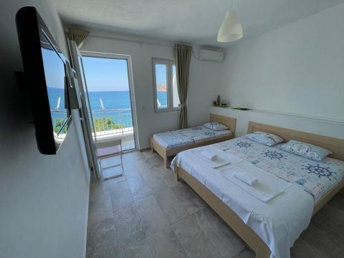 sypialnia z 2 łóżkami i widokiem na ocean w obiekcie Two Palms Apartment w Sutomore
