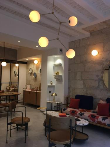 a living room with a couch and chairs and lights at Hôtel L'Adresse in Tours