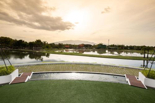 a view of a golf course with a body of water at Thantara Resort Chiang Mai in Chiang Mai