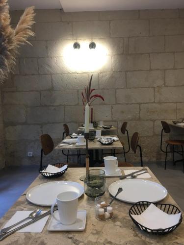 a table with white plates and utensils on it at Hôtel L'Adresse in Tours