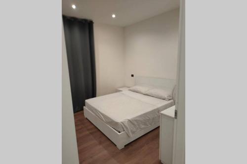 1 dormitorio con 1 cama blanca en una habitación en Appartamento Gisella, en Asti