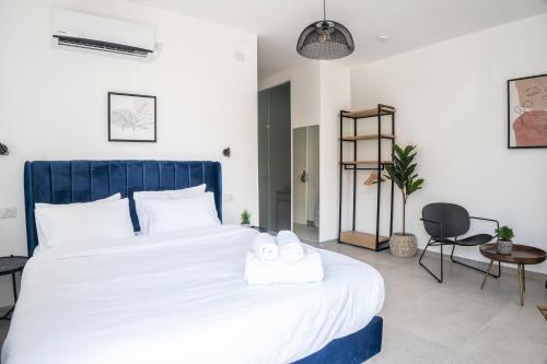 a bedroom with a large white bed with two towels on it at De' Mar Florentine Hotel By Peraia in Tel Aviv