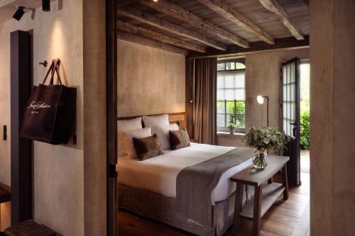 a bedroom with a large bed and a window at La Ferme Saint Simeon Spa - Relais & Chateaux in Honfleur