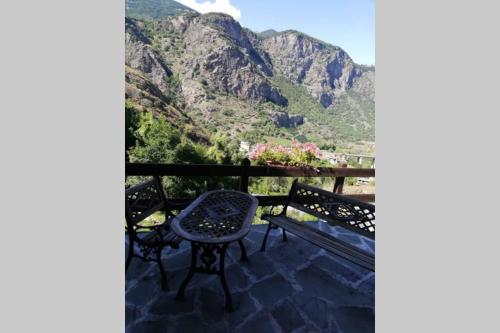 stół i krzesło na balkonie z widokiem na góry w obiekcie SWEET TERRACE w mieście Arvier