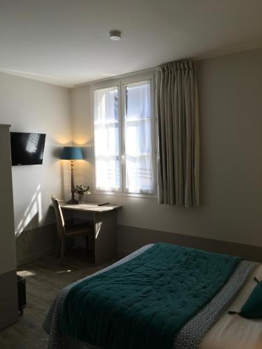 a bedroom with a bed and a desk and a window at Hôtel L'Adresse in Tours
