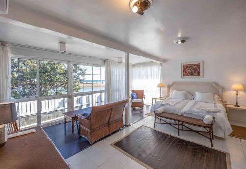 マスパロマスにあるRefurbished Seafront Apartmentのベッドと大きな窓のある寝室