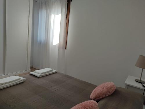 1 dormitorio con 1 cama con almohadas rosas en el suelo en A Apartamentos Diego, en O Grove