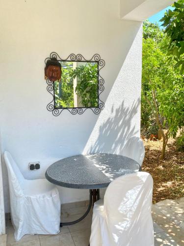 a table and chairs and a mirror on a wall at Guesthouse Gradina in Lovište