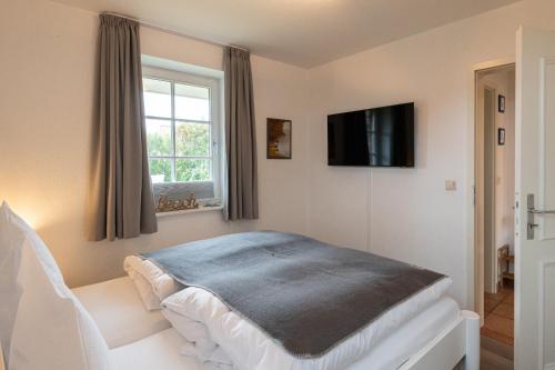 ヴェニングシュテットにあるLH Dwarslöper, App 1のベッド1台と壁掛けテレビが備わる客室です。