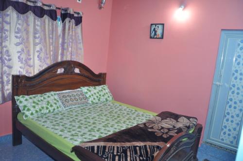 a bedroom with a bed in a room with pink walls at Yelagiri EGV Residency in Yelagiri