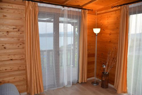 Zimmer mit einem Fenster mit Vorhängen und einer Lampe in der Unterkunft Villa Viridi in Sozopol