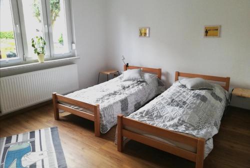 two beds in a room with two windows at Goethestraße 9 in Ballenstedt