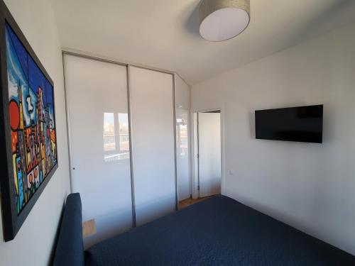 a bedroom with a blue bed and a tv at Bella Vita Dorćol in Belgrade