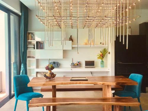 a dining room with a wooden table and blue chairs at Villa MAI MEE PAN HA 3 bedrooms in Nai Yang Beach