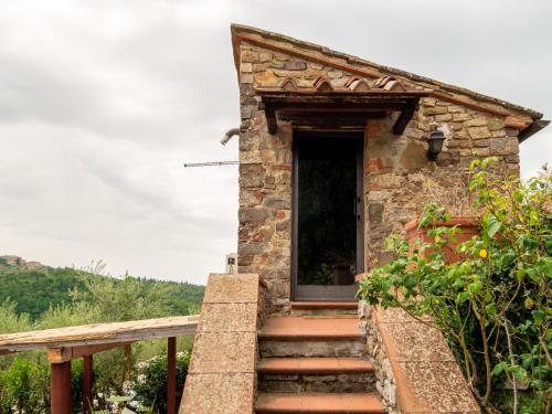 a stone house with stairs leading to a door at Borgo Casa al Vento in Gaiole in Chianti