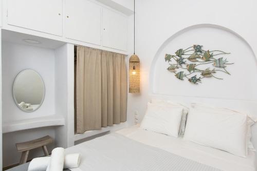 a white bedroom with a bed and a mirror at Sea & City Naxos in Naxos Chora