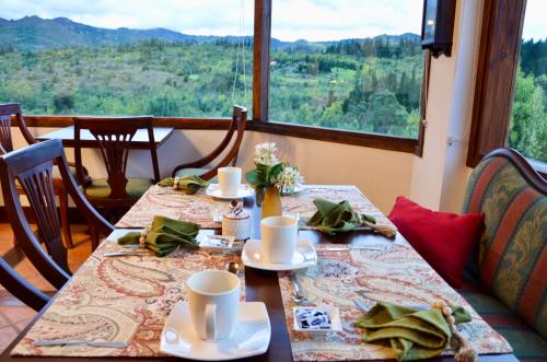 a dining table with a view of the mountains at Sumangá Hotel Boutique in Sutatausa
