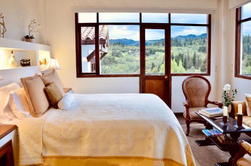 a bedroom with a bed with a large window at Sumangá Hotel Boutique in Sutatausa