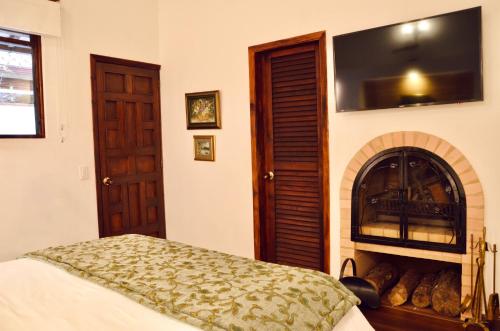 a bedroom with a fireplace with a tv above it at Sumangá Hotel Boutique in Sutatausa