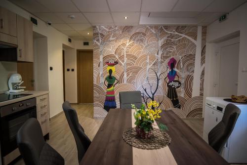 a kitchen with a table and a painting on the wall at Mokka Apartman Szeged in Szeged