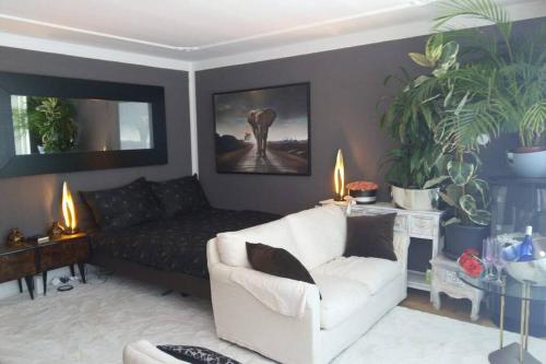 a living room with a couch and a white chair at Penthouse with beautiful 360 terrace in Schaan