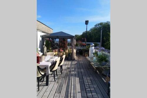 a wooden deck with a table and a gazebo at Penthouse in Schaan in Schaan
