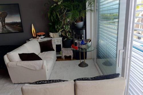 a living room with two white couches and plants at Penthouse in Schaan in Schaan