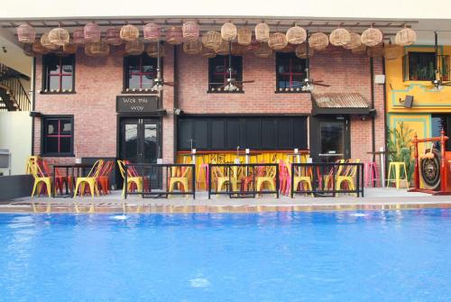 un restaurante con mesas y sillas junto a una piscina en Studio One Hotel, en Dubái