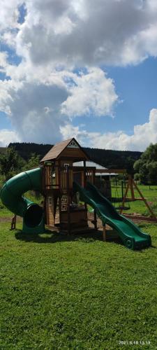 a playground with a slide and a gazebo at Domki - Noclegi Pod Ostrym Działem in Ustrzyki Dolne