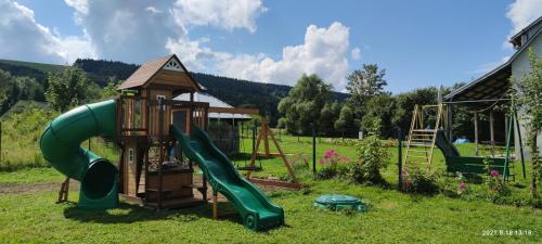 a playground with a slide and a play structure at Domki - Noclegi Pod Ostrym Działem in Ustrzyki Dolne